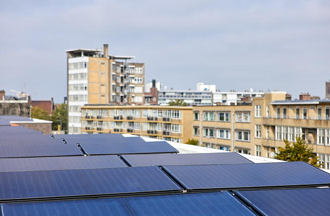 Zonnepanelen met appartementen op de achtergrond