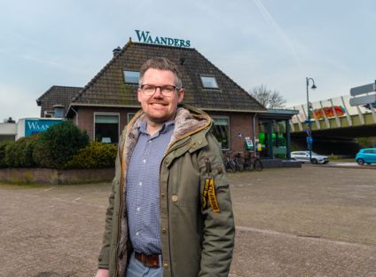 Man lachend op een parkeerplaats voor een voormalig hotel restaurant
