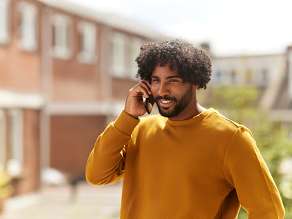 Man lachend aan het bellen met telefoon in handen