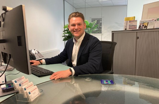 Financieel adviseur Jilles Bouter die lachend aan zijn bureau zit