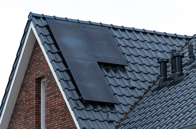 Zijaanzicht van een dak met drie zonnepanelen erop