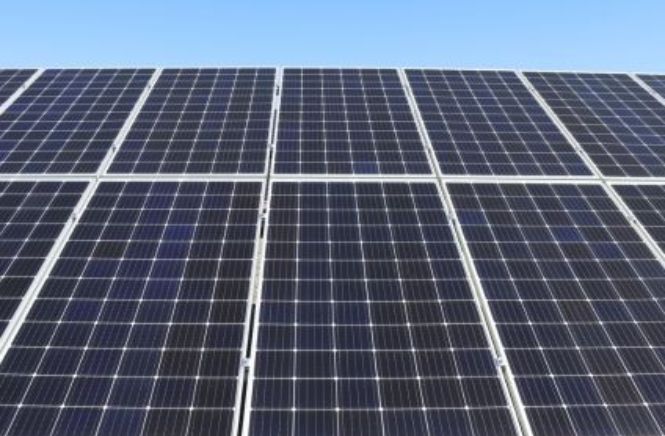 Meerdere zonnepanelen op een rij met een blauwe lucht op de achtergrond