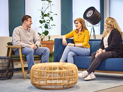 Drie collega's zittend in gesprek en aan het lachen
