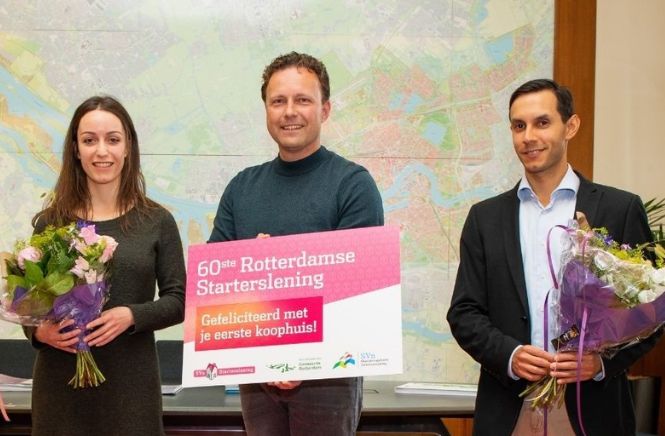 Drie mensen op een rij met een cheque in hun handen in verband met 60E Starterslening in Rotterdam