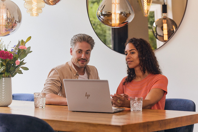 Man en vrouw die samen informatie aan het opzoeken zijn op de laptop