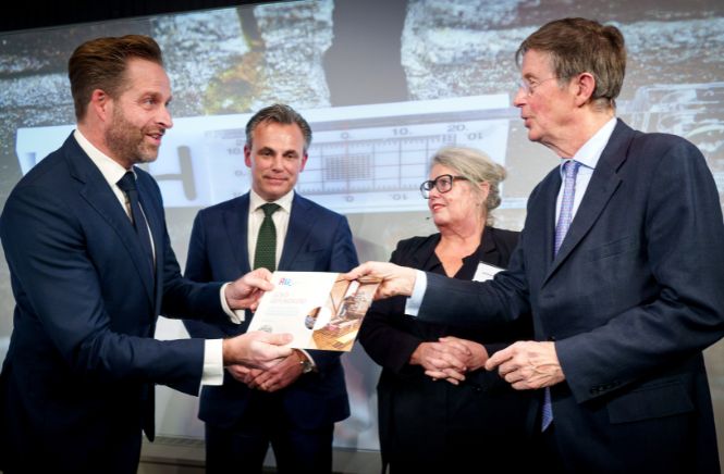 Hugo de Jonge die een cheque overhandigd aan een andere man