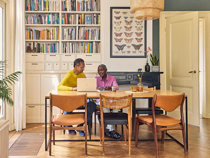 Ouder koppel samen zittend aan tafel achter een laptop